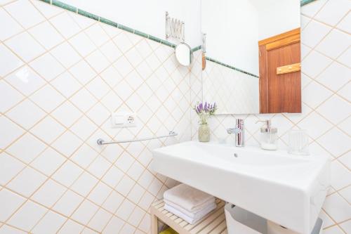 a white bathroom with a sink and a mirror at Son Bou in Sóller