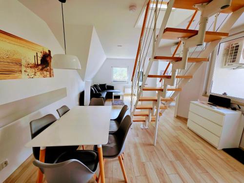 a room with stairs and a table and chairs at De Luxe Blue Mare in Łukęcin