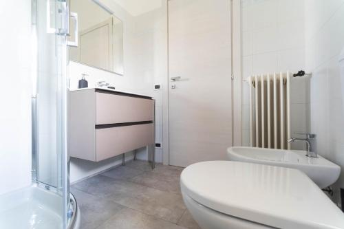 a white bathroom with a toilet and a sink at Villa Livia in Toscolano Maderno