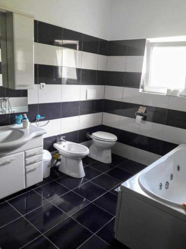 a black and white bathroom with two toilets and a tub at Casa Ionela nr 13- Complex de pensiuni si Casute la Munte in Ceahlău