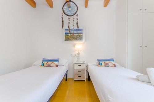 two beds in a room with white walls at Cala Dor 14 in Cala d´Or