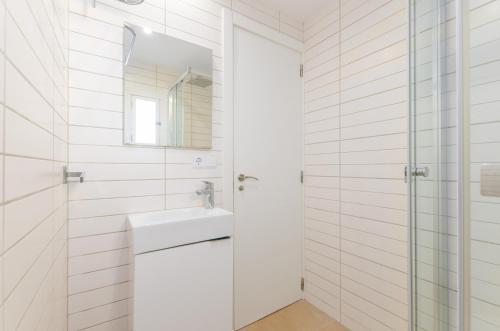 a white bathroom with a sink and a mirror at Cala Dor 14 in Cala d´Or