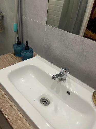 a white sink in a bathroom with a mirror at Million Gold Gdańsk in Gdańsk