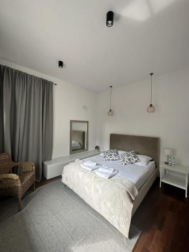 a bedroom with a bed and a chair and a mirror at Villa Masoneria in Łódź