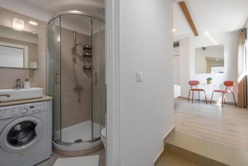 a bathroom with a shower and a washing machine at House Prenc in Pazin