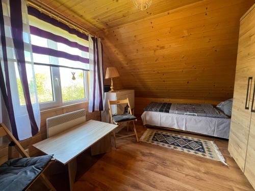 a bedroom with a bed and a desk in a cabin at Domek Twórczy Kąt in Święta Katarzyna