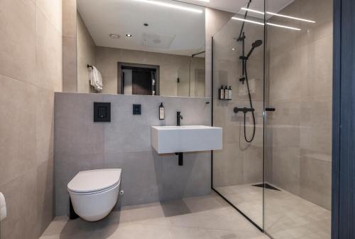 a bathroom with a shower and a toilet and a sink at Thon Hotel Andrikken in Andenes