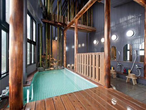 a swimming pool in a house with a wooden deck at Hanano Koyado Jyu-bei in Toba