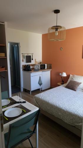 a bedroom with a bed and a table with plates on it at Studio La passagère in Plouvorn