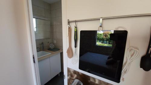 a small room with a mirror in a kitchen at Studio La passagère in Plouvorn