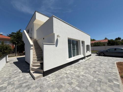 a white house with a staircase on a driveway at Apartment daal Seline in Seline