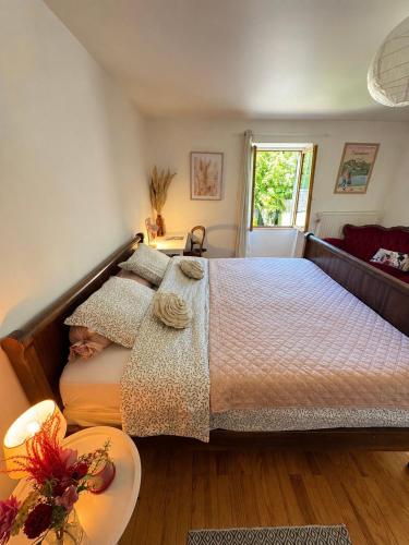 a bedroom with a large bed and a table at CHEZ LOU - Grand espace cosy 60 m2 entrée indépendante dans maison privée au calme in Bucey-lès-Gy