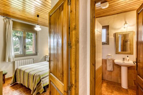 a bathroom with a bed and a sink in a room at Mas Pareta - La Morera in Fonolleras