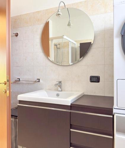 a bathroom with a sink and a mirror at Lilac Cozy Retreat in Angera
