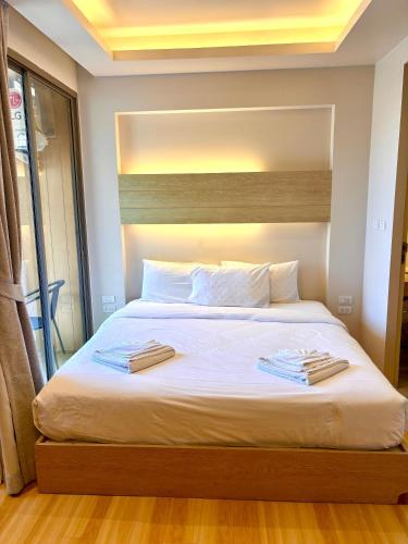 a bedroom with a large bed with two towels on it at Coconut Studio Aonang in Ao Nang Beach