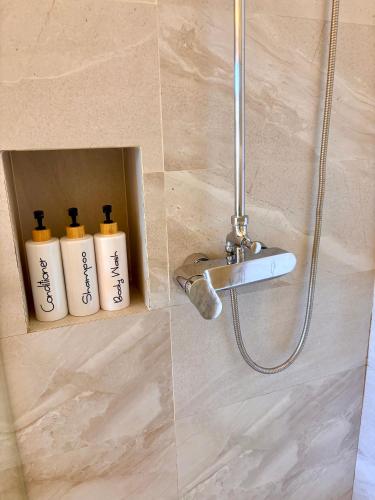 a bathroom with two bottles of soap in a shower at Coconut Studio Aonang in Ao Nang Beach