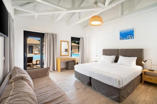 a bedroom with a large bed and a couch at Almyra Holiday Village in Edipsos