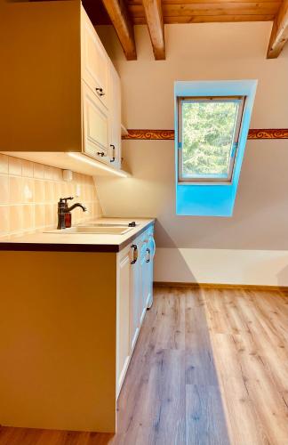 a kitchen with a sink and a window at Ubytování u Chladů in Horská Kvilda