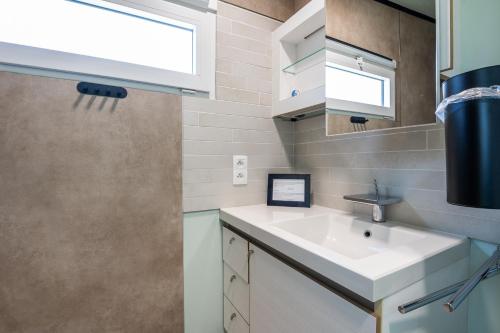 a bathroom with a sink and a window at Wonderful chalet in De Haan in De Haan