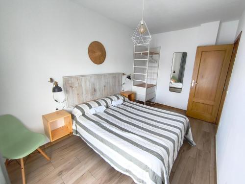 a bedroom with a bed and a chair at Apartamentos DEVA in Unquera
