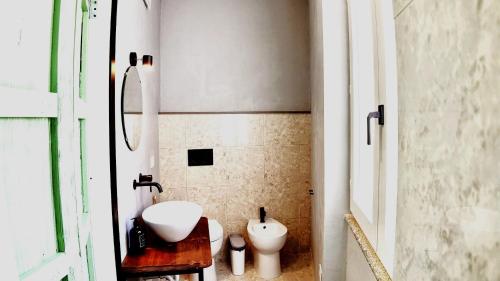a bathroom with a white sink and a toilet at META Affittacamere in Càbras