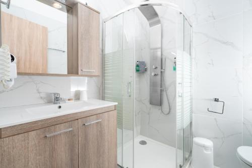 a bathroom with a shower and a sink and a toilet at Almyra Holiday Village in Edipsos