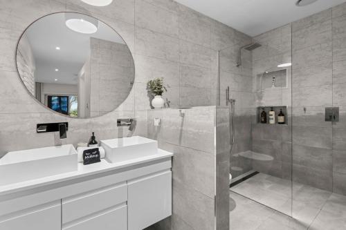 a bathroom with a sink and a mirror at Werri Big Beach House in Gerringong