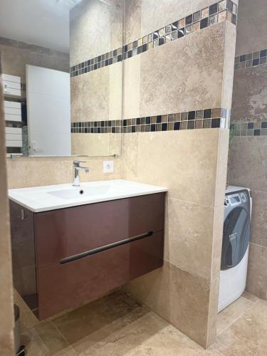 a bathroom with a sink and a washing machine at LE TERRACOTTA COTE D'AZUR - Proche PLAGE - Terrasse & Confort - CLIM - Parking et Wifi Gratuit- OFFRE SPECIALE in Fréjus
