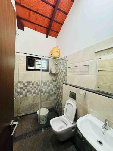 a bathroom with a toilet and a sink at Rego Farms in Mangalore