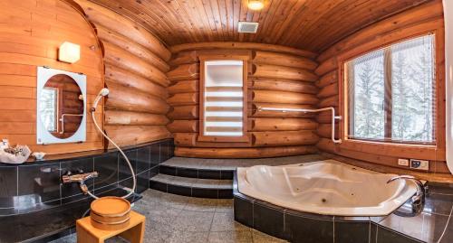 a bathroom in a log cabin with a tub at Villa Rusutsu in Rusutsu