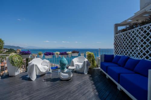 ein blaues Sofa und weiße Stühle auf einem Balkon in der Unterkunft Aquaboutique Wellness&Spa in Vietri