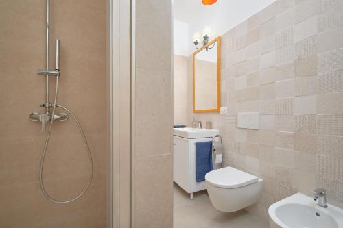 a bathroom with a shower and a toilet and a sink at Casa vacanze vento di mare in Alghero