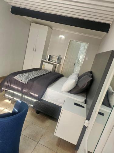 a small bedroom with a bed and a desk at Fullmoon Homes 9A in Edenvale