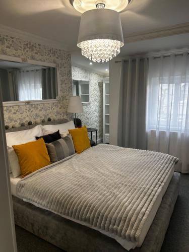 a bedroom with a large bed and a chandelier at The Manor in Pilsen