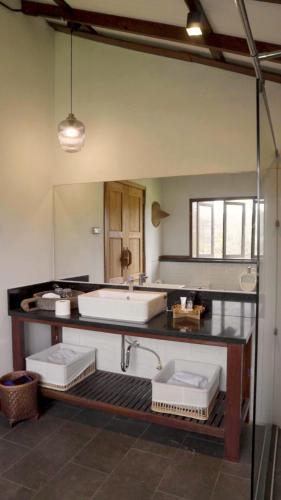 a bathroom with two sinks and a large mirror at บ้านริมดอย แม่ริม in Ban Mae Raem