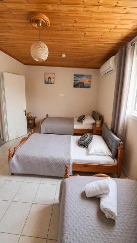a bedroom with two beds and a wooden ceiling at Olive holiday home in Laganas