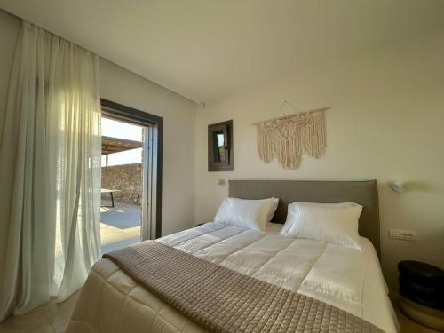 a bedroom with a large bed and a large window at Fenia's Paradise Villa in Houlakia