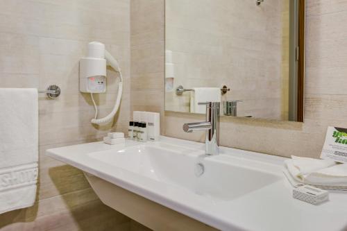 a bathroom with a white sink and a mirror at Plus Hotel Bostanci Atasehir in Istanbul