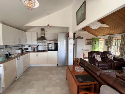 a living room with a couch and a kitchen at Beachcombers in Craobh Haven