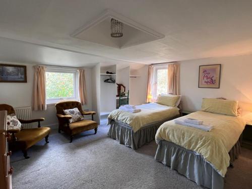 a bedroom with two beds and a chair at Beachcombers in Craobh Haven