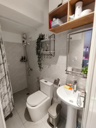 a small bathroom with a toilet and a sink at Arc tower- Sweet Stay Cebu in Cebu City