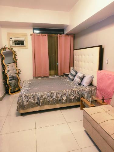 a bedroom with a bed and a couch at Arc tower- Sweet Stay Cebu in Cebu City