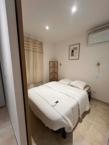 a bedroom with a bed with a phone on it at Les clés de Jules in Gruissan