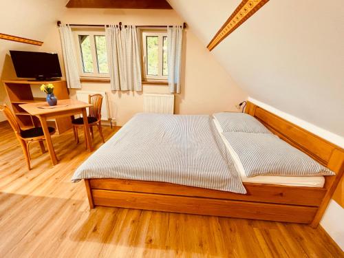 a bedroom with a bed and a desk and a table at Ubytování u Chladů in Horská Kvilda