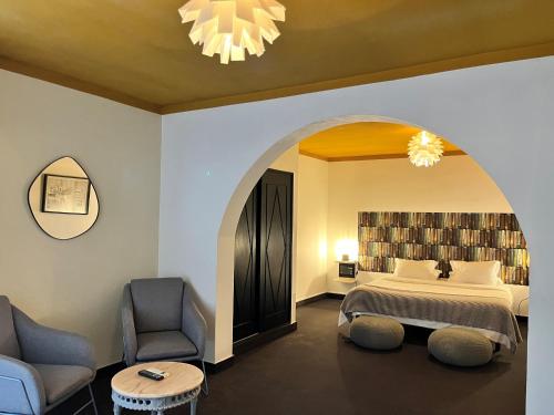 a hotel room with a bed and two chairs at The Literary Man Obidos Hotel in Óbidos