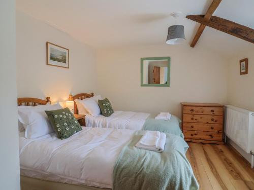 a bedroom with two beds and a dresser at Harbins Farm in Sherborne