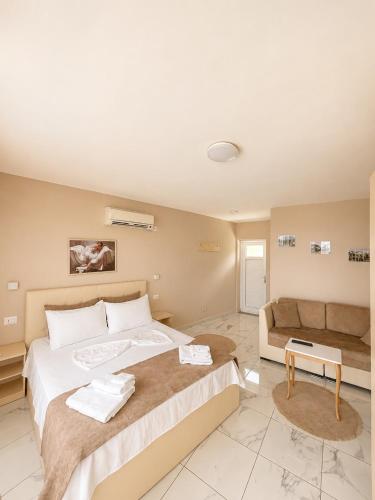 a bedroom with a large bed and a couch at LakeFront House in Shirokë