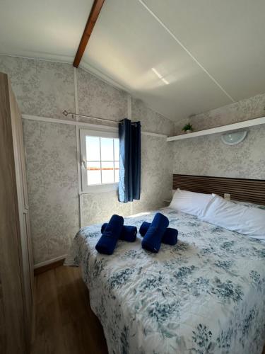a bedroom with a bed with blue pillows on it at Casita la Loma in Cádiz