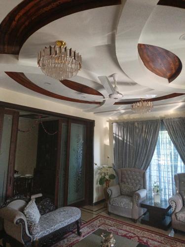 a living room with two chairs and a ceiling at Studio 430 in Islamabad