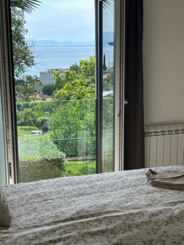 a bedroom with a bed and a large window at Apartmani ViVa in Lovran